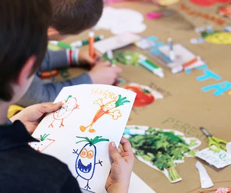 Niños dibujando vegetales en taller